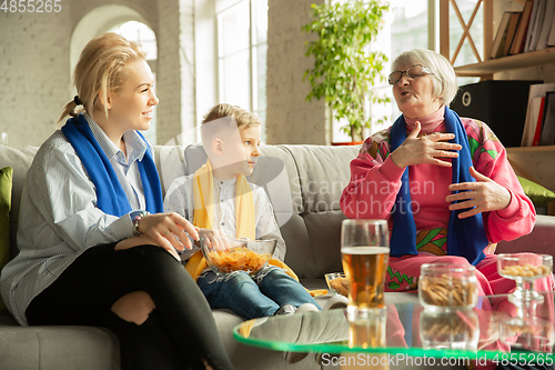 Image of Excited family watching football, sport match at home, grandma, mother and son
