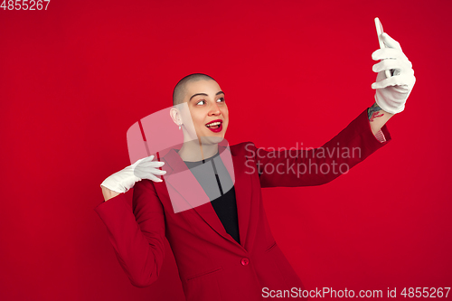 Image of Portrait of young caucasian bald woman on red background