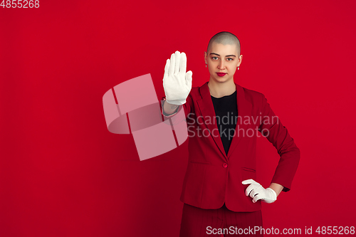 Image of Portrait of young caucasian bald woman on red background