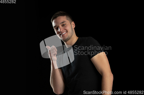 Image of Monochrome portrait of young caucasian man on black studio background