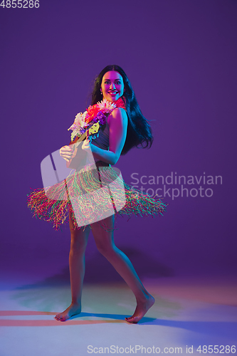 Image of Fabulous Cinco de Mayo female dancer on purple studio background in neon light