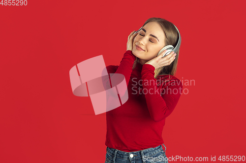 Image of Monochrome portrait of young caucasian blonde woman on red background