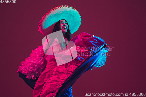 Image of Fabulous Cinco de Mayo female dancer on purple studio background in neon light