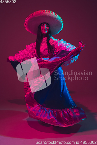 Image of Fabulous Cinco de Mayo female dancer on purple studio background in neon light