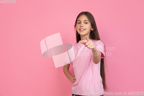 Image of Caucasian little girl portrait isolated on pink studio background, emotions concept