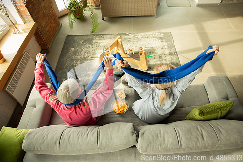 Image of Excited family watching football, sport match at home, grandma and daughter