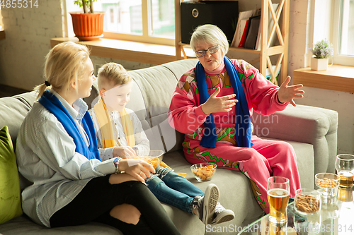 Image of Excited family watching football, sport match at home, grandma, mother and son