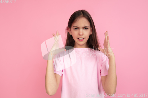 Image of Caucasian little girl portrait isolated on pink studio background, emotions concept