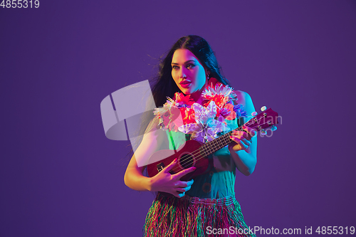 Image of Fabulous Cinco de Mayo female dancer on purple studio background in neon light