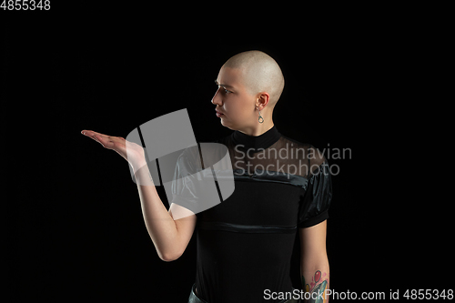 Image of Monochrome portrait of young caucasian bald woman on black background