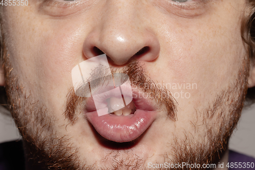 Image of Close-up male mouth illustrating emotions. Cosmetology, dentistry and beauty care, facial expression