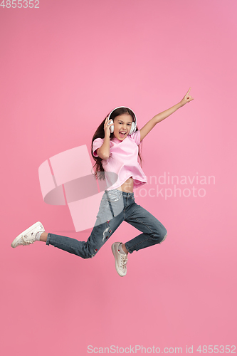 Image of Caucasian little girl portrait isolated on pink studio background, emotions concept