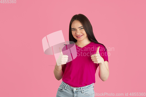 Image of Monochrome portrait of young caucasian brunette woman on pink background