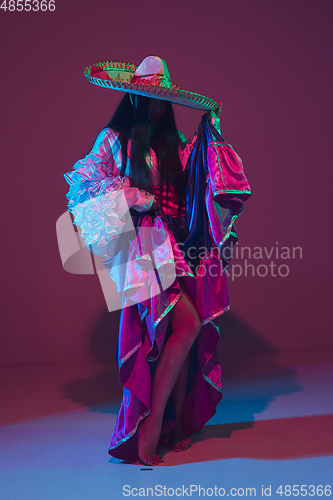 Image of Fabulous Cinco de Mayo female dancer on purple studio background in neon light