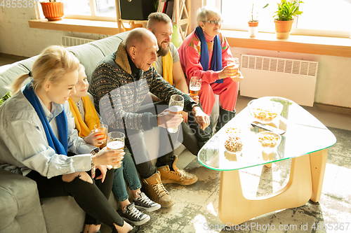 Image of Excited family watching football, sport match at home