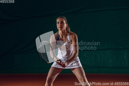 Image of Young caucasian professional sportswoman playing tennis on sport court background