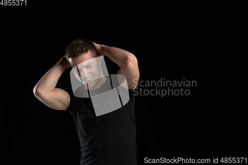 Image of Monochrome portrait of young caucasian man on black studio background