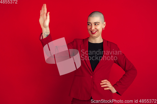 Image of Portrait of young caucasian bald woman on red background