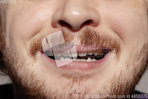 Image of Close-up male mouth illustrating emotions. Cosmetology, dentistry and beauty care, facial expression