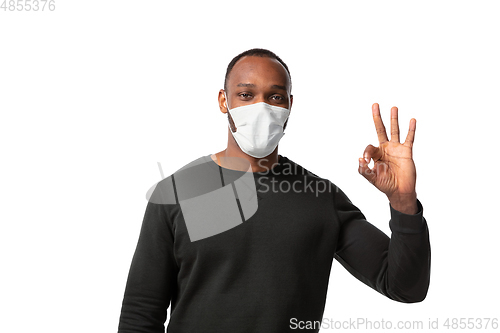 Image of How coronavirus changed our lives. Young man wearing face mask to stop spreading on white background