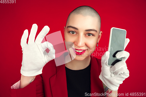 Image of Portrait of young caucasian bald woman on red background