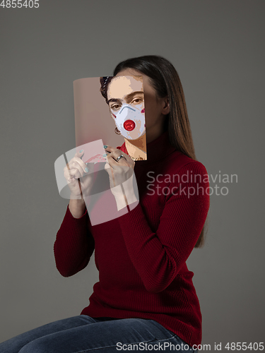 Image of Be safe and read to become someone else - woman covering face with book in face mask while reading on grey background