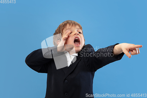 Image of Portrait of a young orthodox jewish boy isolated on blue studio background, meeting the Passover