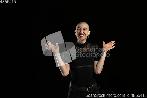 Image of Monochrome portrait of young caucasian bald woman on black background