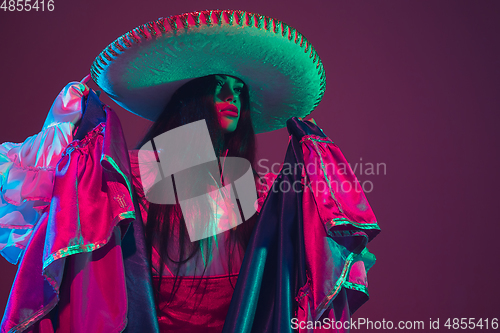 Image of Fabulous Cinco de Mayo female dancer on purple studio background in neon light