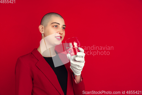 Image of Portrait of young caucasian bald woman on red background