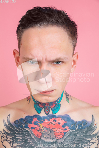 Image of Portrait of young man with freaky appearance on pink background