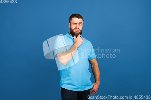 Image of Caucasian man\'s portrait isolated on blue studio background with copyspace