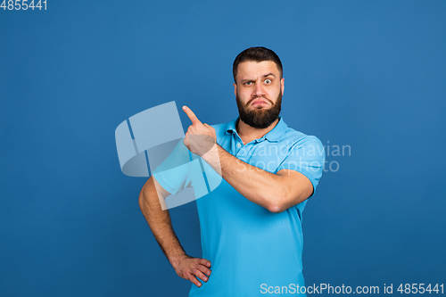 Image of Caucasian man\'s portrait isolated on blue studio background with copyspace