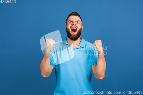 Image of Caucasian man\'s portrait isolated on blue studio background with copyspace