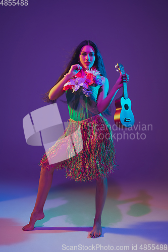 Image of Fabulous Cinco de Mayo female dancer on purple studio background in neon light