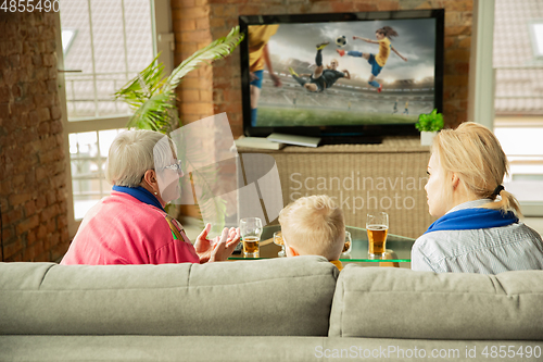 Image of Excited family watching football, sport match at home, grandma, mother and son