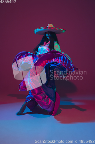 Image of Fabulous Cinco de Mayo female dancer on purple studio background in neon light