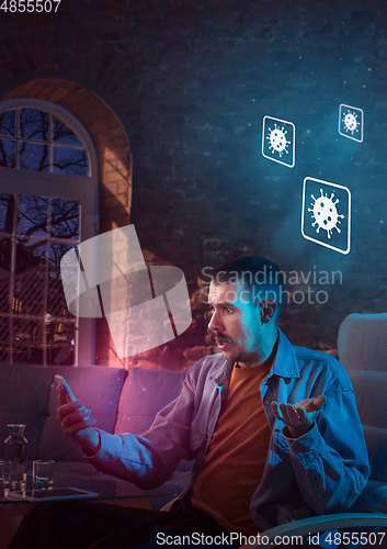 Image of Shocked, upset and sad man using gadgets to get information of coronavirus pandemic spread