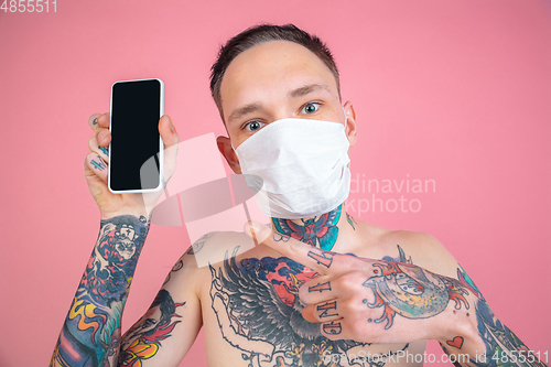 Image of Portrait of young man with freaky appearance on pink background