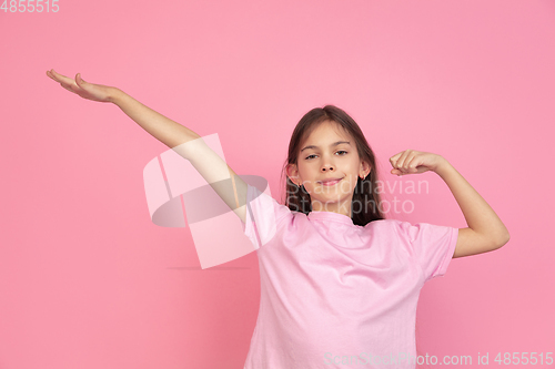 Image of Caucasian little girl portrait isolated on pink studio background, emotions concept