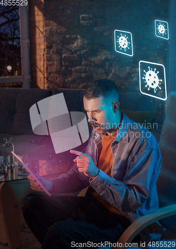 Image of Shocked, upset and sad man using gadgets to get information of coronavirus pandemic spread