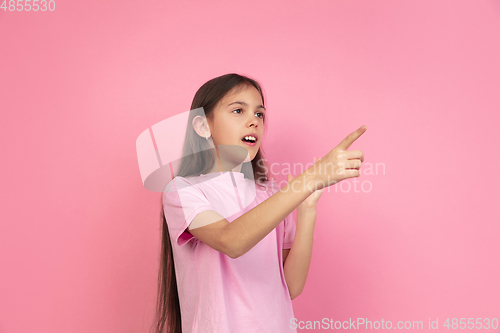 Image of Caucasian little girl portrait isolated on pink studio background, emotions concept