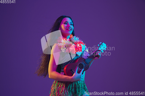 Image of Fabulous Cinco de Mayo female dancer on purple studio background in neon light