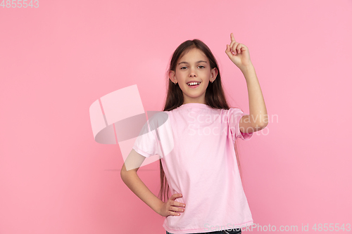 Image of Caucasian little girl portrait isolated on pink studio background, emotions concept