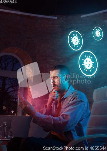 Image of Shocked, upset and sad man using gadgets to get information of coronavirus pandemic spread