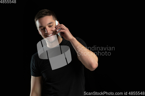 Image of Monochrome portrait of young caucasian man on black studio background