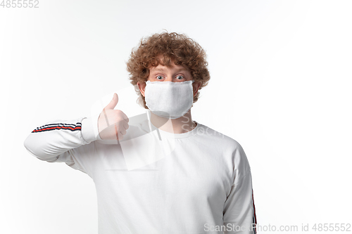 Image of How coronavirus changed our lives. Young man wearing face mask to stop spreading on white background