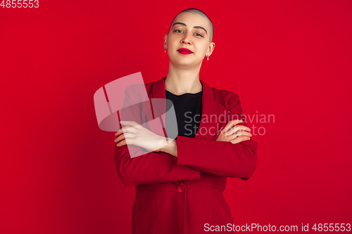 Image of Portrait of young caucasian bald woman on red background