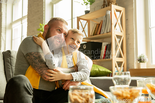 Image of Excited family watching football, sport match at home, father and son