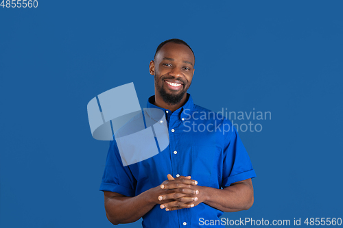 Image of Monochrome portrait of young african-american man on blue studio background